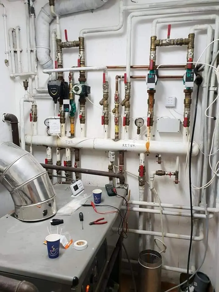 Cameră tehnică cu distribuitoare, pompe de circulație și robineți pe fiecare circuit