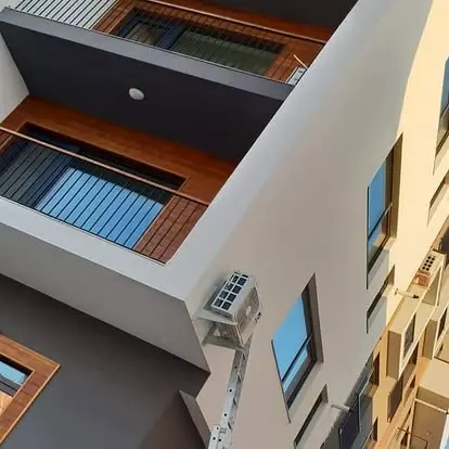 Unitate exterioară montată pe fațada unui bloc nou, între balcoane